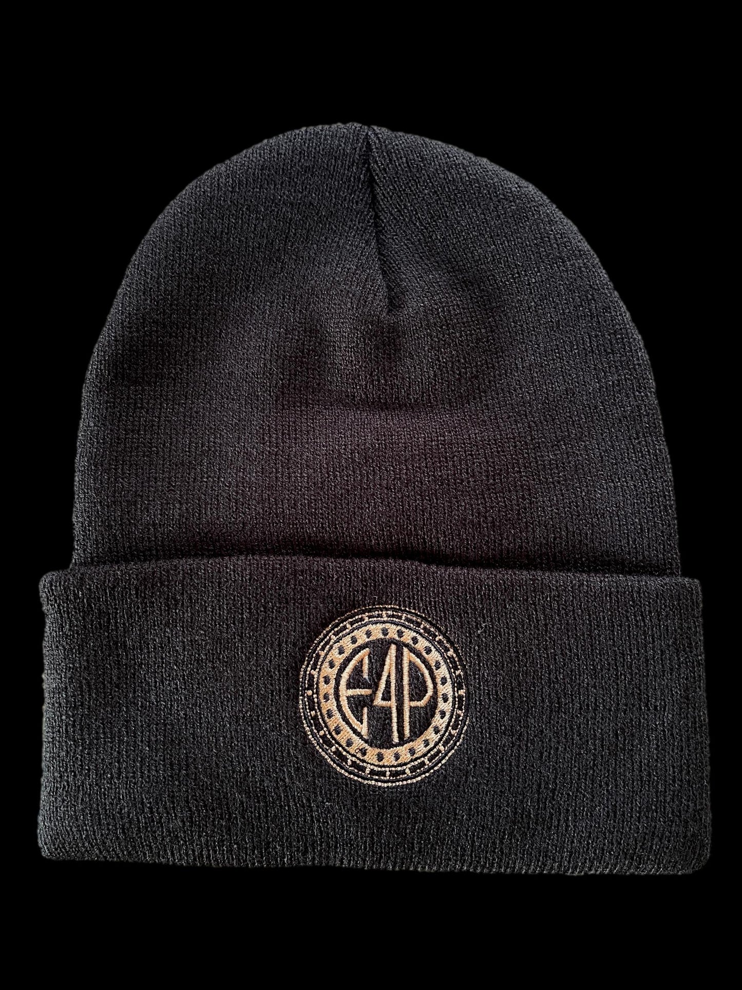 A black cuffed beanie with a textured design and a gold stamp logo on the front.